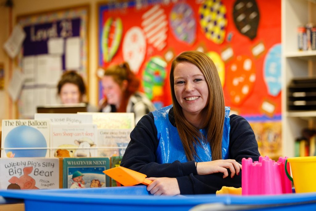 Early years student smiling in play setting