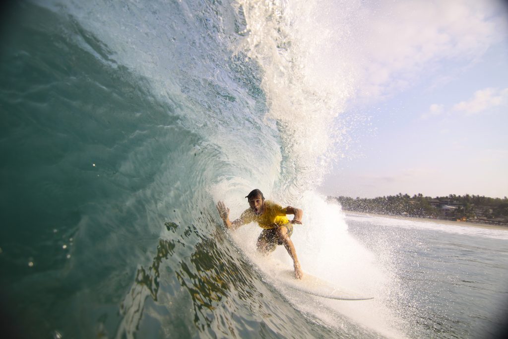 Surfer making his way into a blue water barrel 