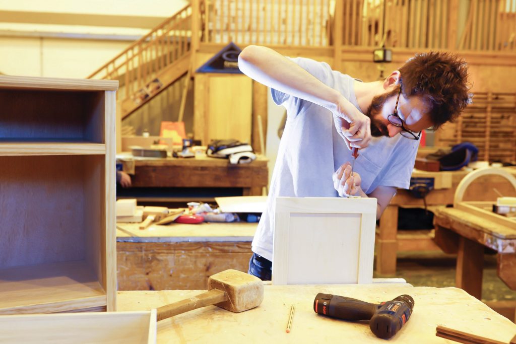 Furniture student working on a piece in workshop