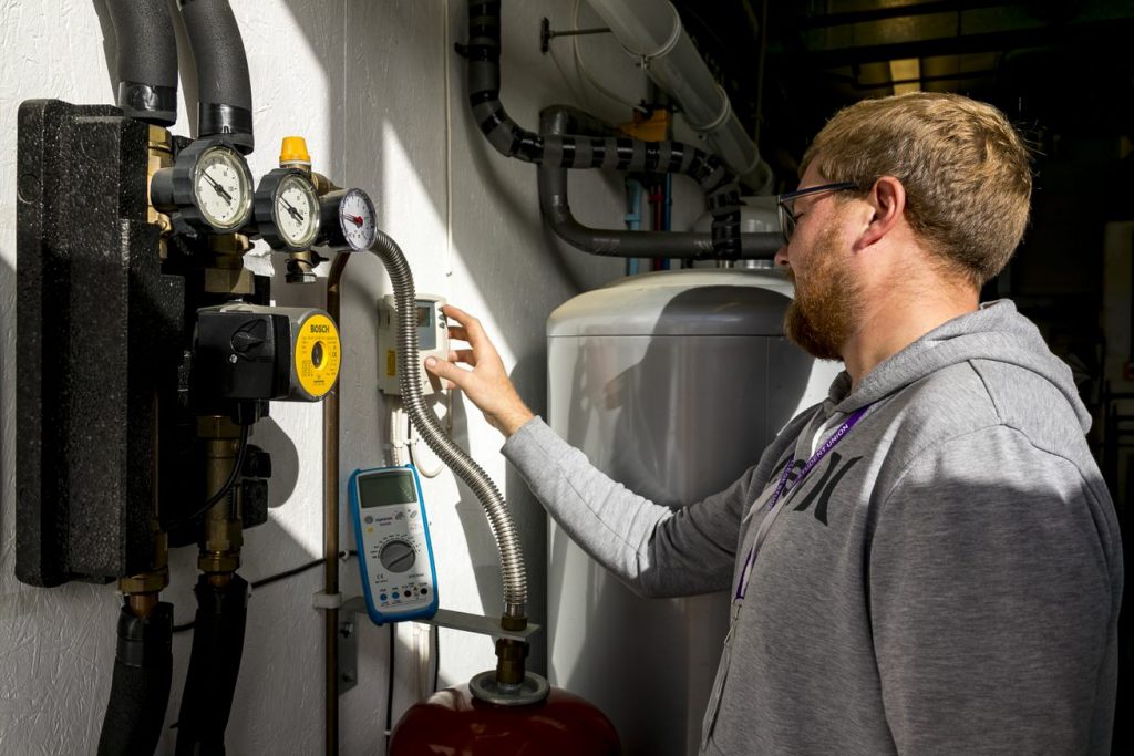 Man checking plumbing meters