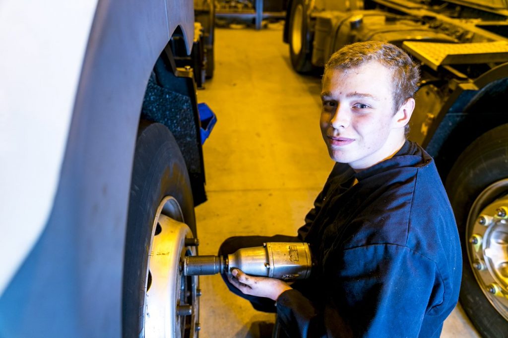 Motor vehicle student working on a car's rim