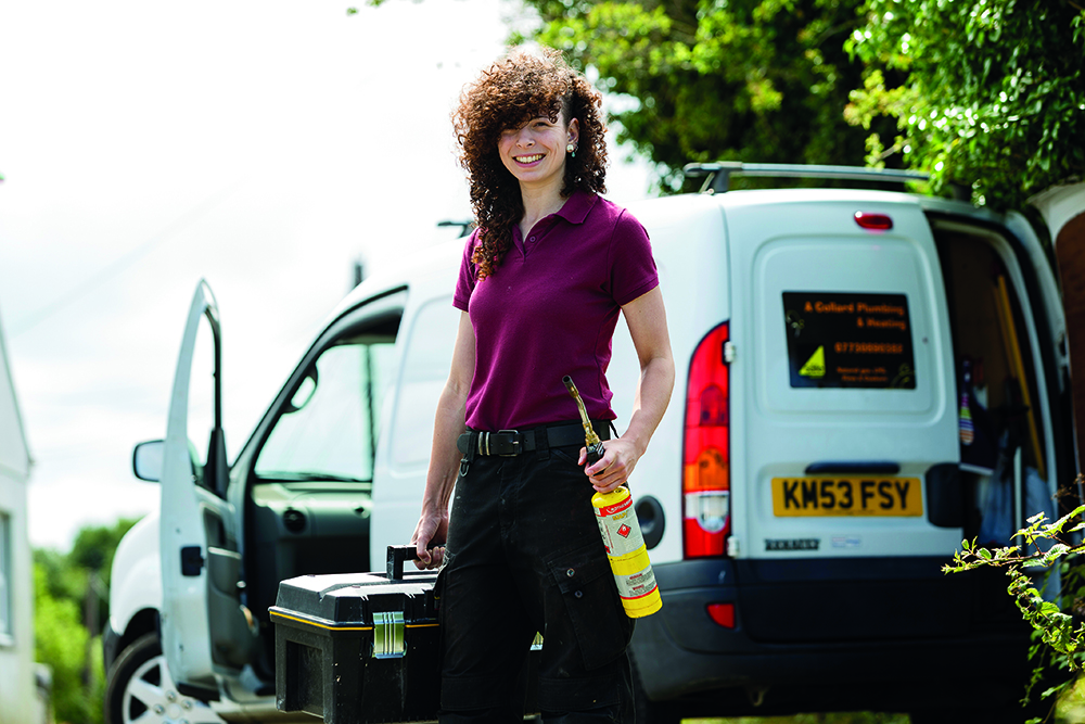 Female student smiling while standing in front of white van