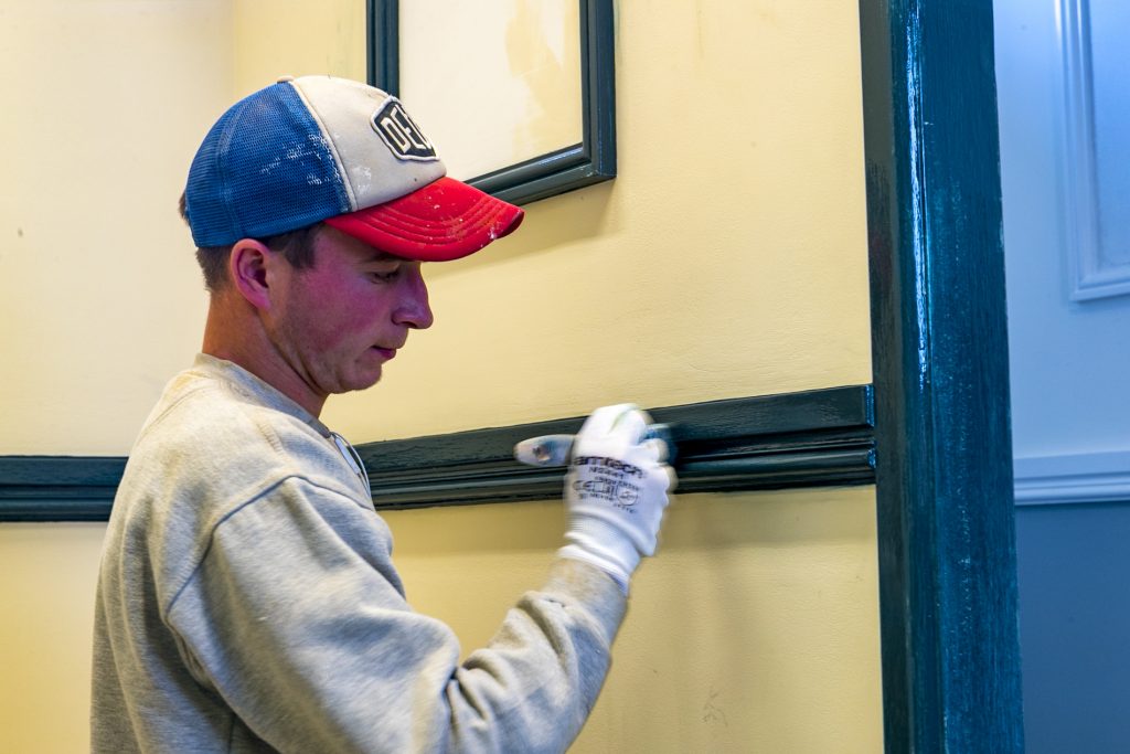 Man working on wall with a brush