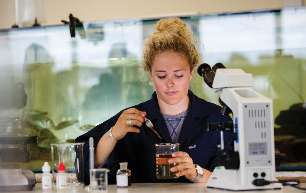 Student working with a liquid substance in laboratory 